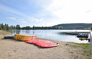 Un lago tranquilo con kayaks y un muelle.