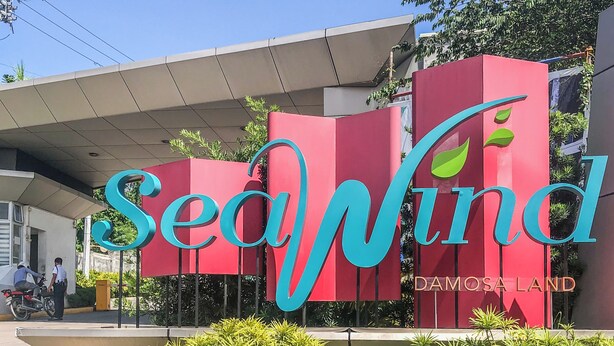 A building with a prominent red and blue sign reading 'SeaWind' and 'Damosa Land'. - Seawind Condominium (Davao City)