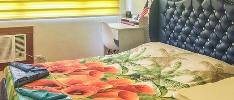 Un dormitorio con cama, escritorio y ventana con persianas.