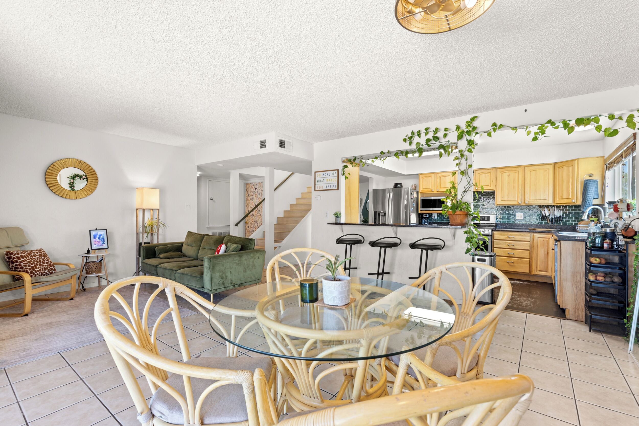 Un appartement moderne comprenant un salon, un coin repas, une cuisine et un escalier.