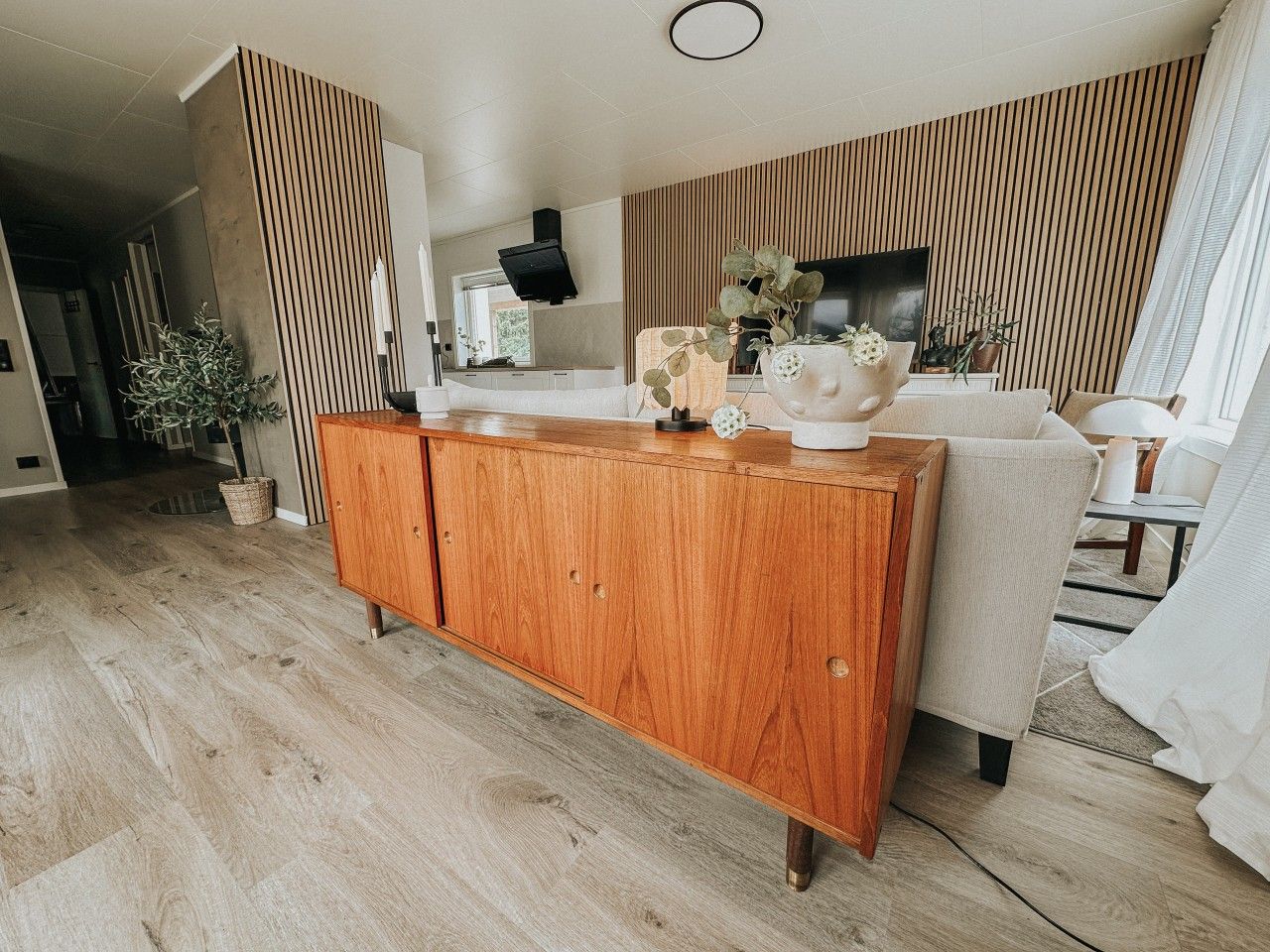 A modern living room with a wooden cabinet, a sofa, and a television.