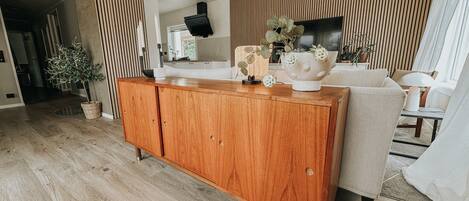 A modern living room with a wooden cabinet, a sofa, and a television.
