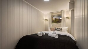 Une chambre d’hôtel avec un lit, des oreillers et une fenêtre avec des rideaux.