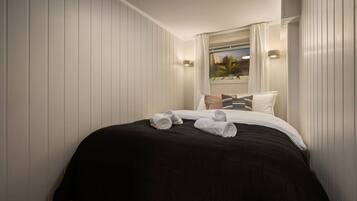 Ein Hotelzimmer mit Bett, Kissen und einem fensterbepflanzten Fenster.