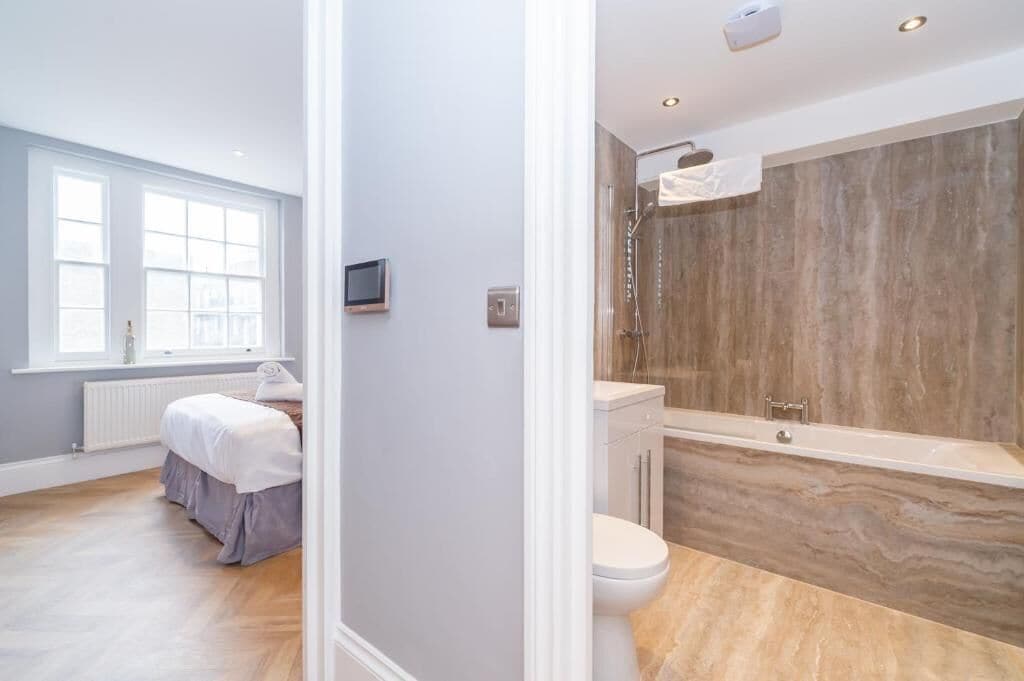 Une salle de bain moderne équipée d’une baignoire, de toilettes et d’une douche.
