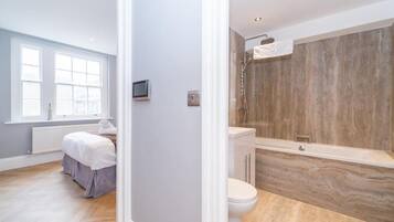 Une salle de bain moderne équipée d’une baignoire, de toilettes et d’une douche.