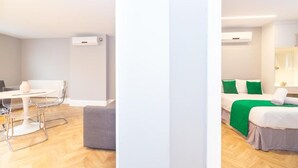Una habitación de hotel moderna con una cama, una mesita pequeña y una silla.