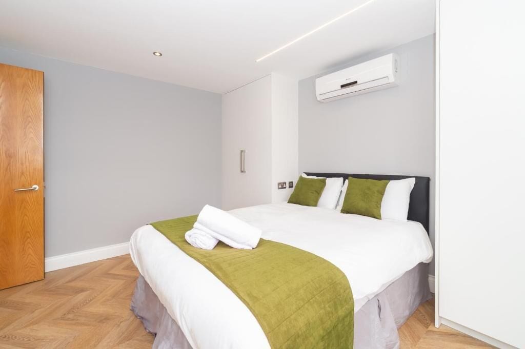 Ein Hotelzimmer mit einem Bett, einer Tür und einer Klimaanlage.