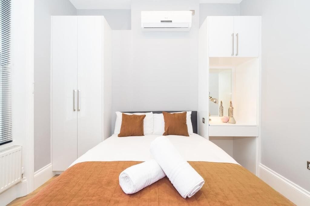 Ett hotellrum med en säng, en garderob och en spegel.