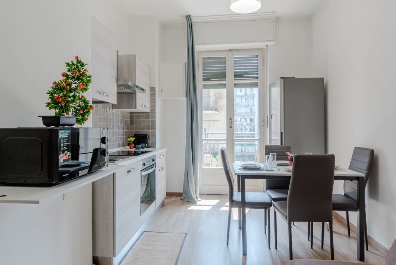 Une cuisine compacte comprenant un coin repas, un réfrigérateur et une fenêtre avec vue.