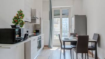 Una cocina compacta con comedor, refrigerador y ventana con vistas.