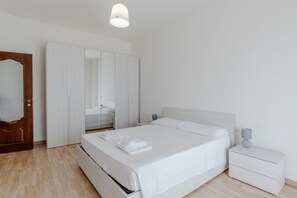 A bedroom with a bed, bedside tables, a wardrobe, and a mirror. - A bright and comfortable 48 square meters apartment, perfect for three people, located on the third floor of a renovated building with an elevator (NOT accessible to people with disabilities).The property is situated in an extremely quiet area well-serve (Turin)