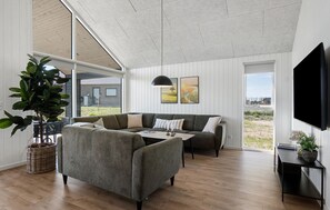 A modern living room with a sectional sofa, a coffee table, and a flat-screen TV. - Nice home in Otterup with WiFi (Otterup)