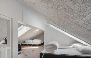 A compact, well-lit attic bedroom with a sloped ceiling, a bed, a small seating area, and a visible skylight. - Nice home in Otterup with WiFi (Otterup)