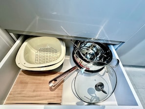 A kitchen area with a stove, a sink, and a wooden cutting board. - Spacious modern 2BR apartment Phu Quoc (Phu Quoc)