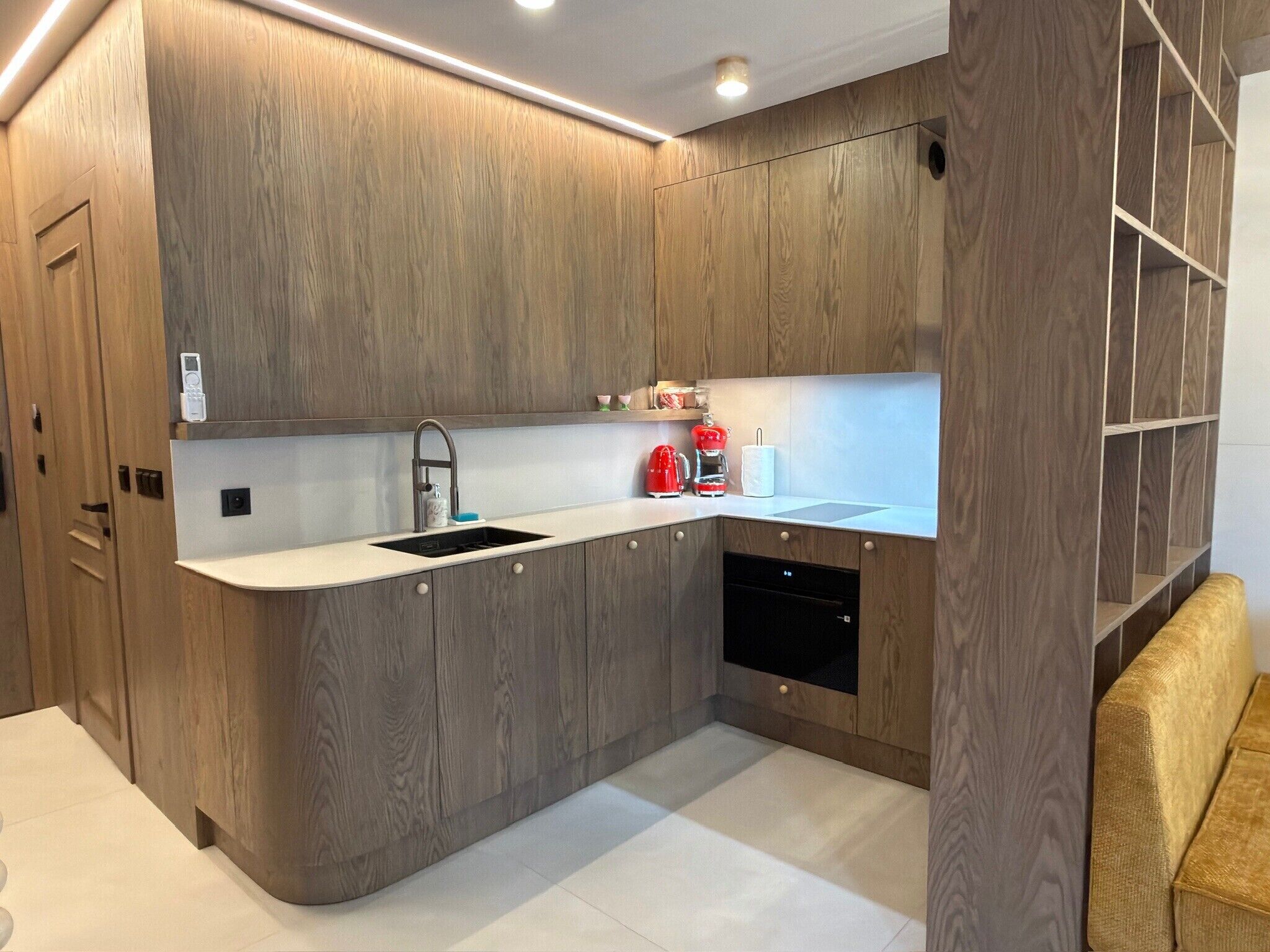 Una cocina moderna con armarios de madera, lavavajillas integrado y una encimera con fregadero.