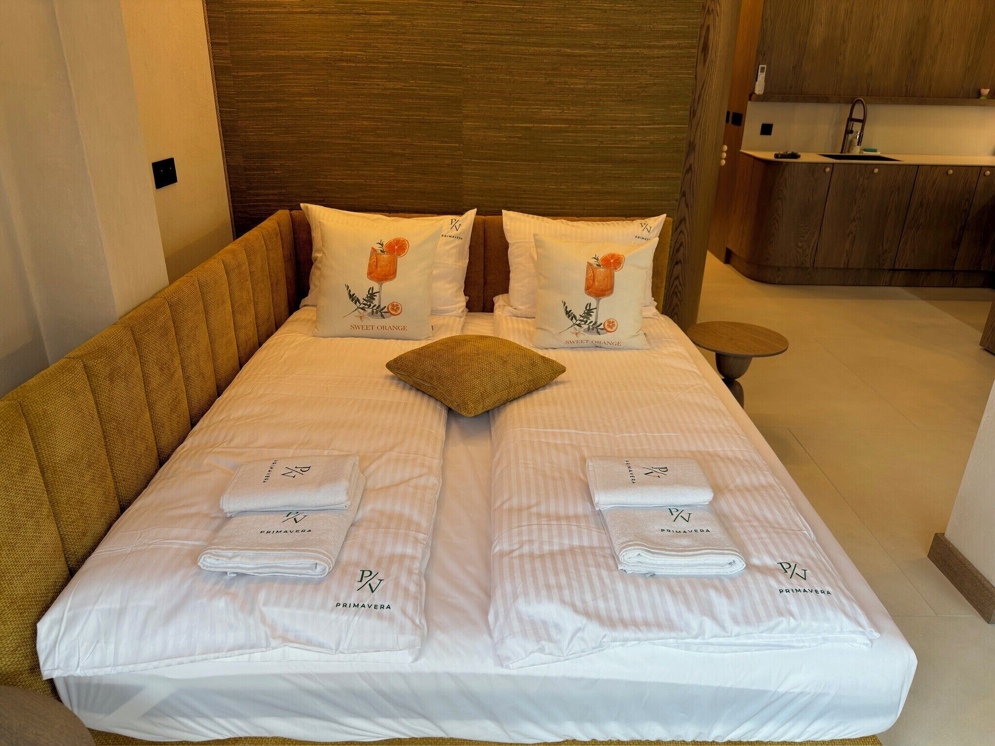 A hotel room with a bed, pillows, and towels.