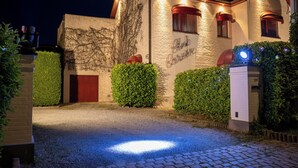 Un edificio con camino de grava y entrada bien iluminada.