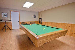 A pool table with a green felt surface, surrounded by wooden paneling and a wooden floor. - Panoramic Views, Sunrise/Sunset, EV Charger Kayaks (Magnetawan)