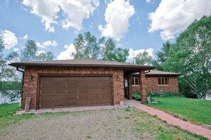 A single-story brick house with a large garage door, a small attached garage, and a covered porch. - Panoramic Views, Sunrise/Sunset, EV Charger Kayaks (Magnetawan)