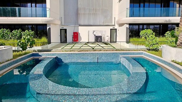 A modern building with a swimming pool, balconies, and a vertical garden. - 48 Parkside - 603 1BD (Dubai)