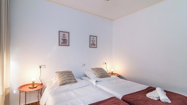 A hotel room with two beds, a small table, and two wall-mounted lamps. - LXR Fuengirola Sun & Beach 2-Bedroom (Fuengirola)