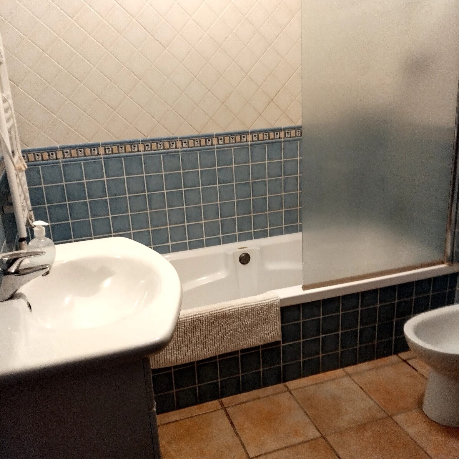 Un baño con lavamanos blanco, bañera y retrete.