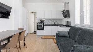 A modern kitchen with white cabinets, a black countertop, and a built-in oven. - La Corte Vermena by Wonderful Italy (Bologna)