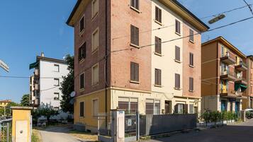 Ein mehrgeschossiges Wohngebäude mit Ziegelaußenwand, zahlreichen Fenstern und einem ehrfurchtgebietenden Eingang.