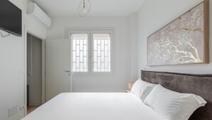 A bedroom with a bed, a window with a view, and a painting on the wall. - La Corte Vermena by Wonderful Italy (Bologna)