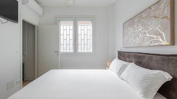Ein Schlafzimmer mit einem Bett, einem Fenster mit Blick und einem Bild an der Wand.
