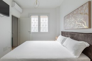 Ein Schlafzimmer mit einem Bett, einem Fenster mit Blick und einem Bild an der Wand.