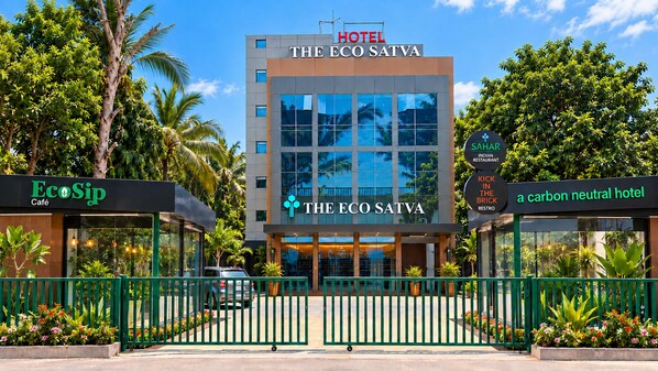 A hotel named 'The Eco Satva' with a sign indicating it's a carbon neutral hotel.