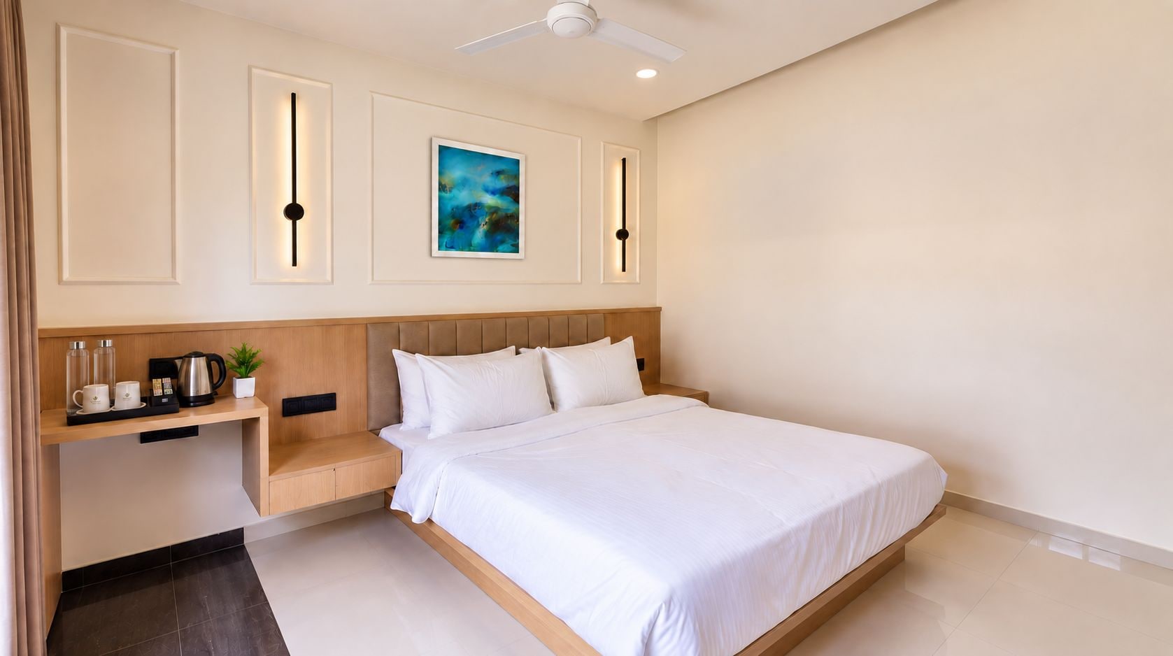A hotel room with a bed, bedside table, and a painting on the wall.