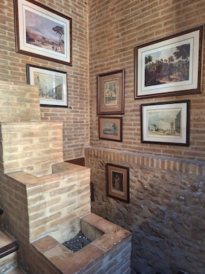 A brick wall with multiple framed pictures. - Lotel Casa Noble La Solana (València)