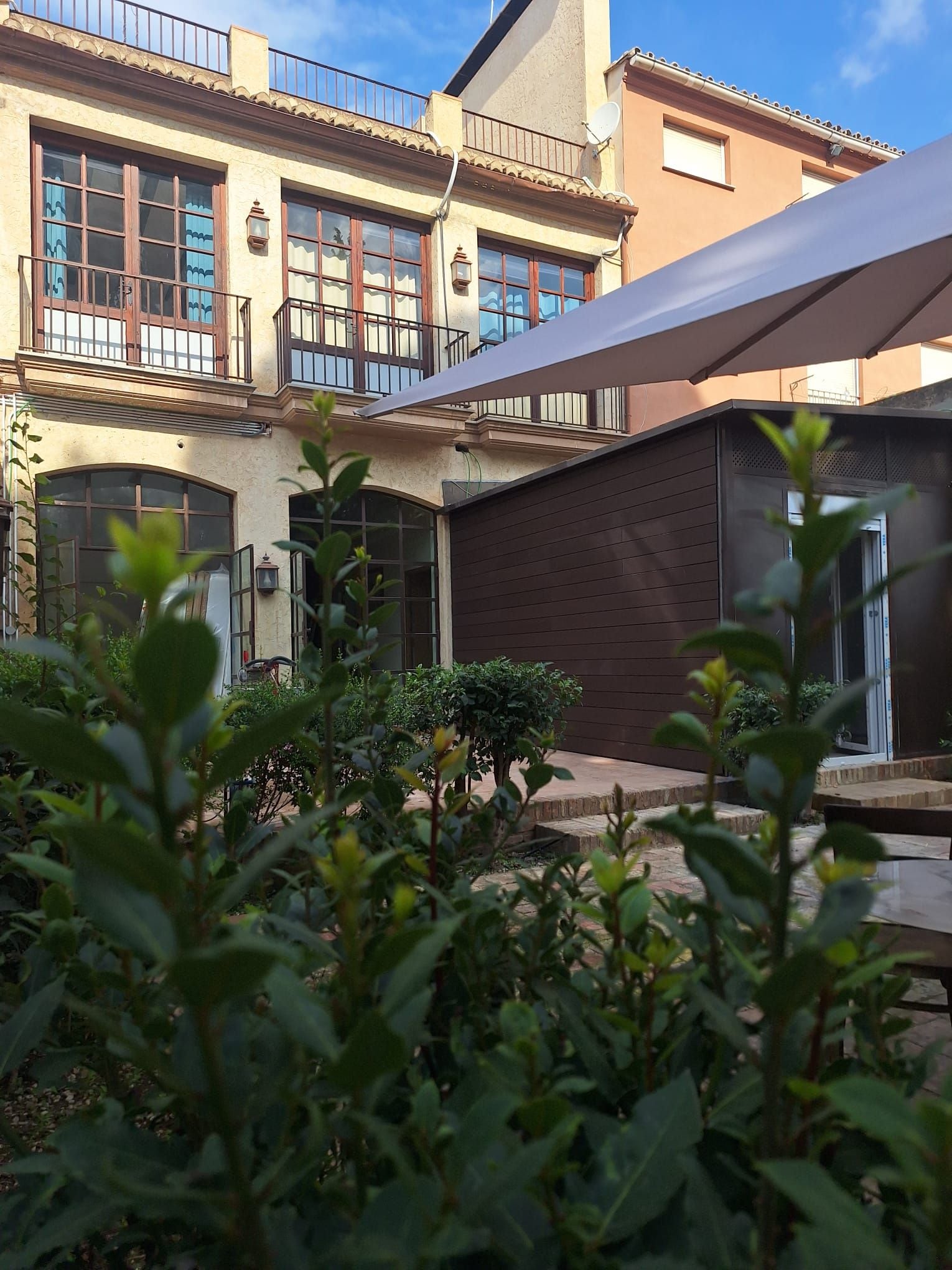 A courtyard with a building featuring large windows and a balcony.