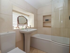 A bathroom with a toilet, sink, mirror, and bathtub. - Lyndhurst (Leyburn)