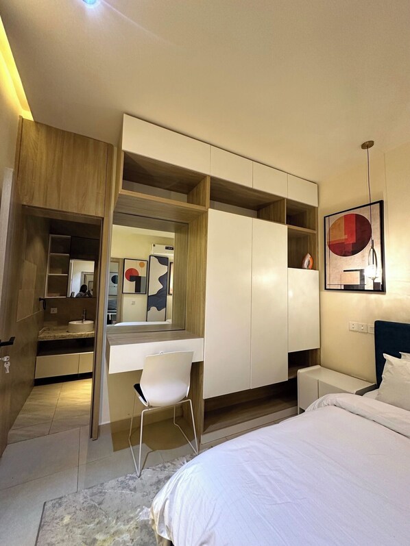 A modern bedroom with a built-in desk, a bed, and a wardrobe. - Aden 360 By Intra (Abuja)