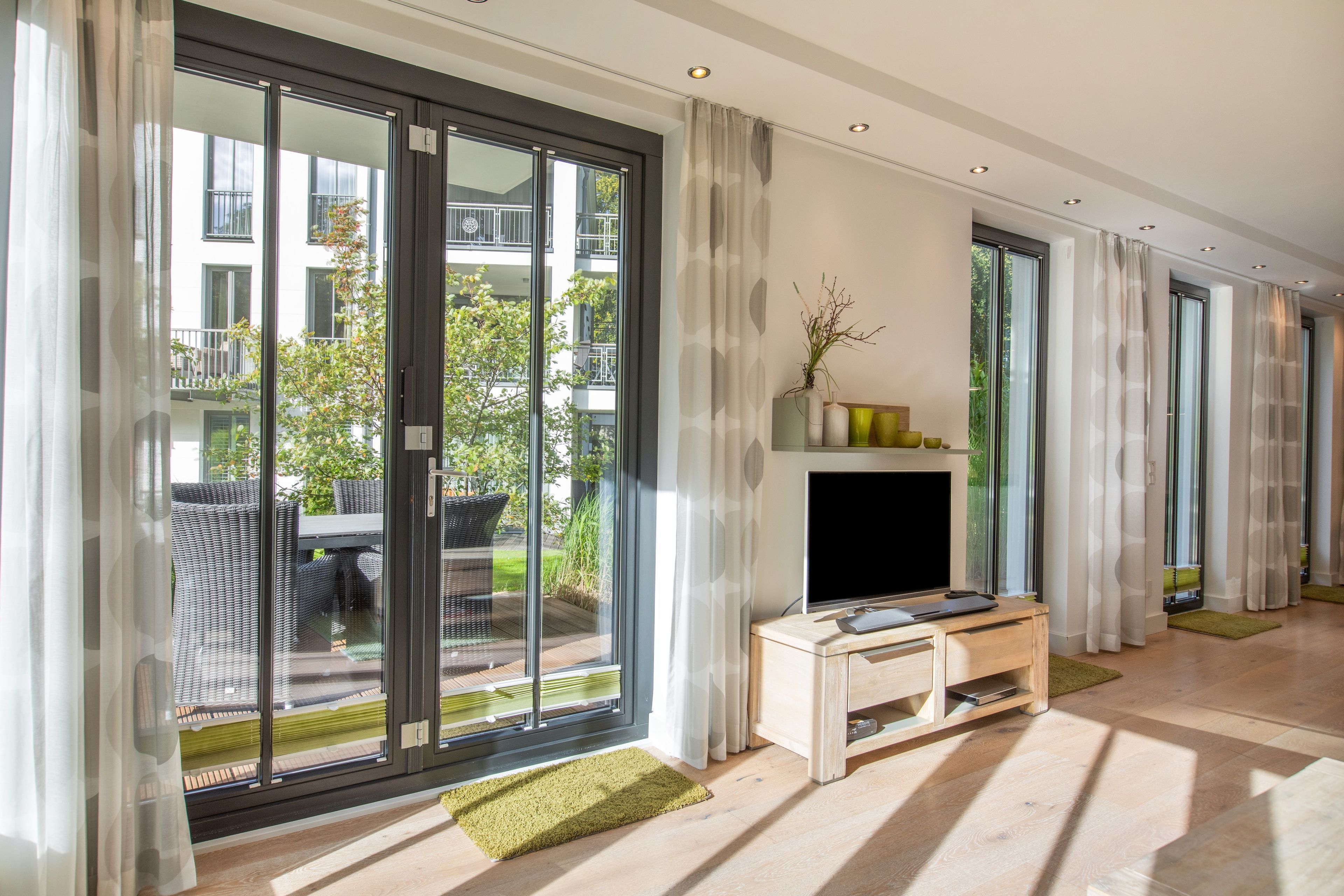 A modern living room with a fireplace, large sliding glass doors, and a view of the outdoors.