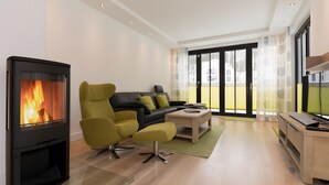 Un salon moderne avec une cheminée, un canapé, une table basse et un meuble pour la télévision.