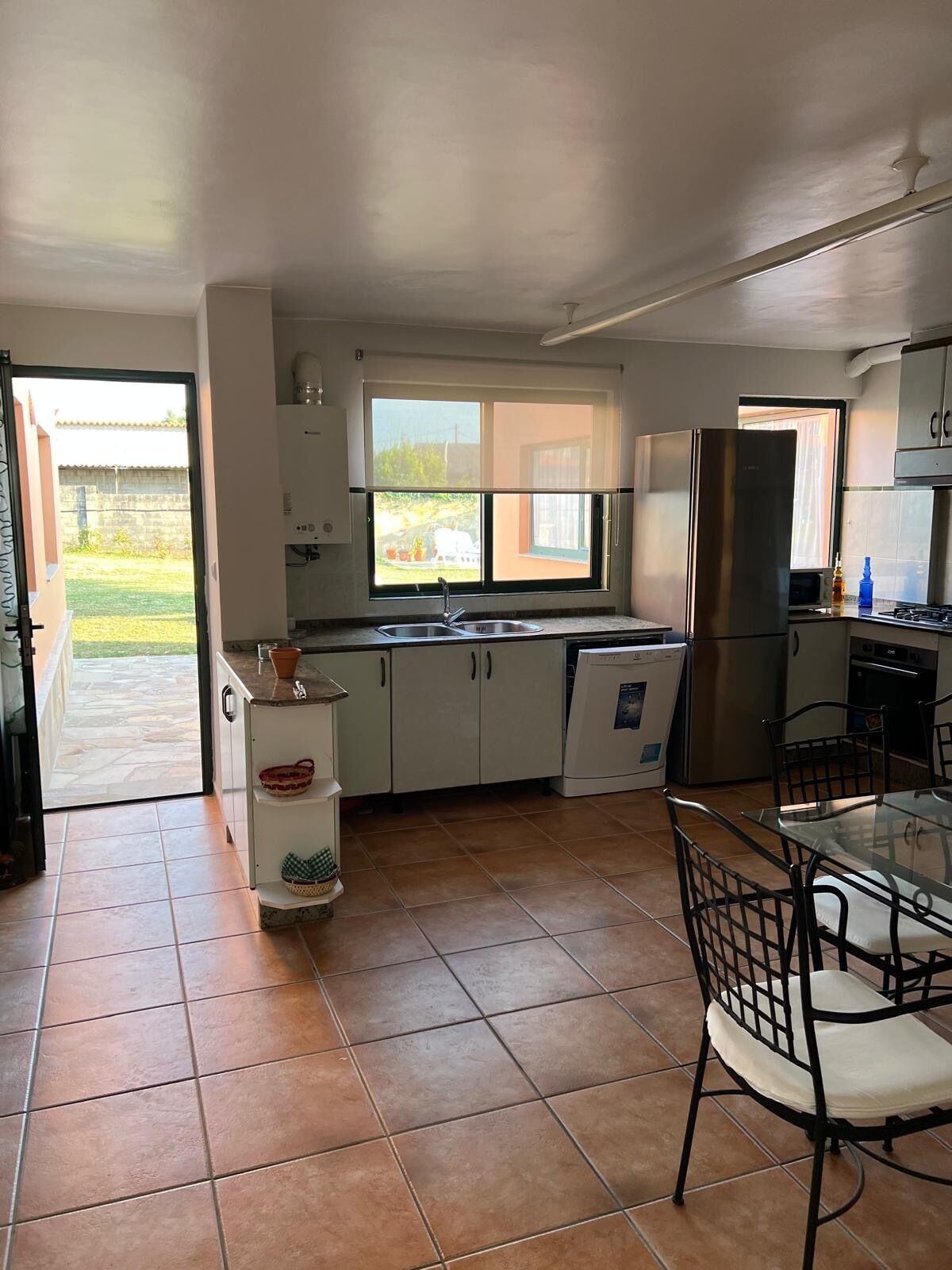 A compact kitchen with a dining area, a window, and a view of the outdoors.