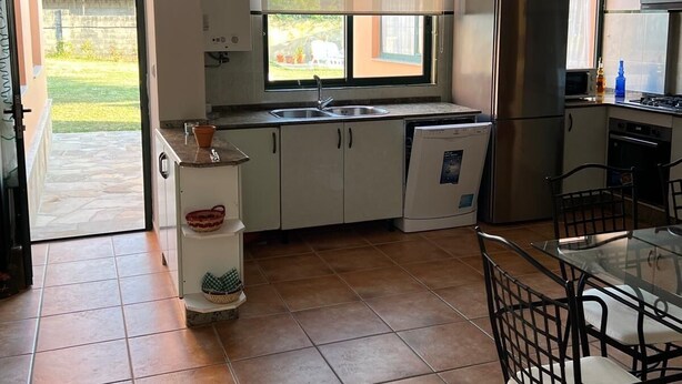 Eine kleine Küche mit Essbereich, einem Fenster und Blick ins Freie.