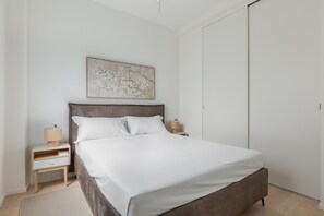 A bedroom with a bed, nightstands, a lamp, a painting, and a wardrobe. - La Corte Vermena by Wonderful Italy (Bologna)