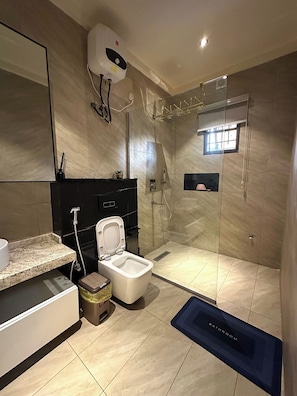 A modern bathroom with a glass-enclosed shower, a toilet, a sink, and a mirror. - Mofam Hotel & Apartments (Osogbo)