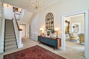 A staircase with a carpeted landing, a blue cabinet with lamps, and a red rug. - Peaceful 6-bedroom house for family and group in charming Berwick-upon-Tweed (Berwick-upon-Tweed)