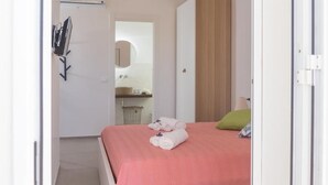 A bedroom with a bed, a wardrobe, a mirror, and a sink. - Marezè (Santa Croce Camerina)
