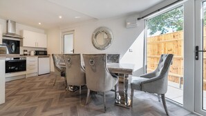 Uma cozinha moderna com área de refeições, janelas amplas e padrão de piso em herringbone.