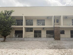 A multi-story building with a flat roof, outdoor seating area, and a paved courtyard. - Mevis Boutique Hotel (Bulawayo)