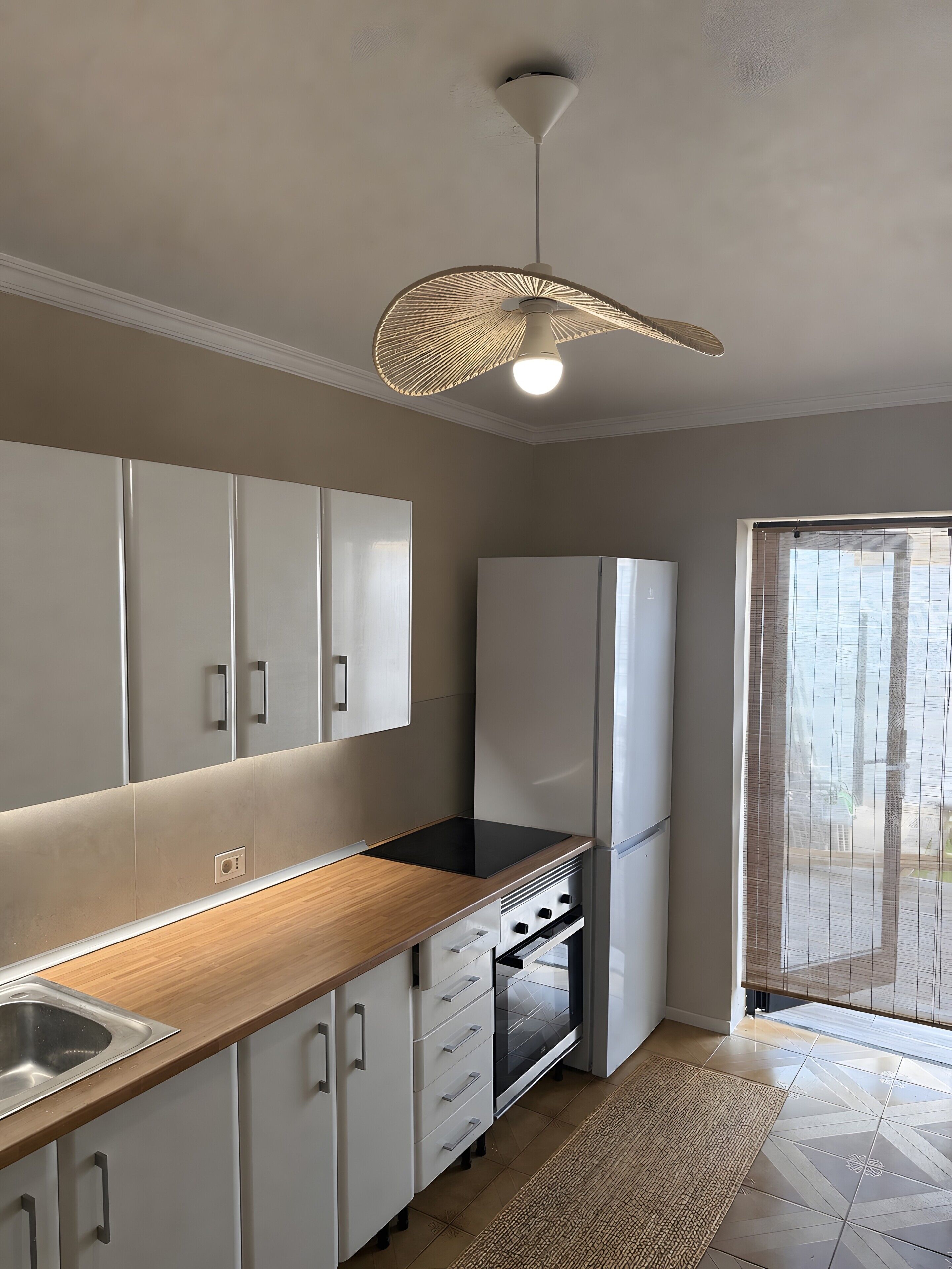 A modern kitchen with a built-in oven, a sink, and a wooden countertop.