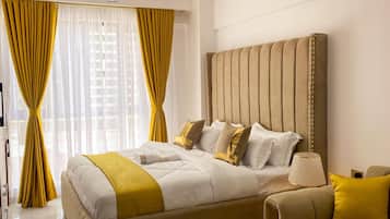 A modern bedroom with a large bed, a headboard with vertical lines, and a bedside table with a lamp.